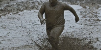 Gordo corriendo en el barro