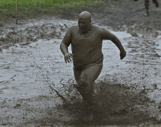 Gordo corriendo en el barro